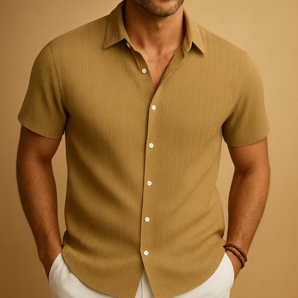 Man wearing a khaki short-sleeve shirt against a beige background